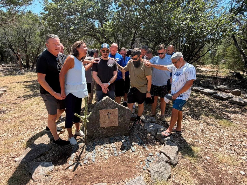 Men praying around the Testify stone at Oak Ridge